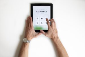 Person using index finger to navigate social media icons on a tablet.